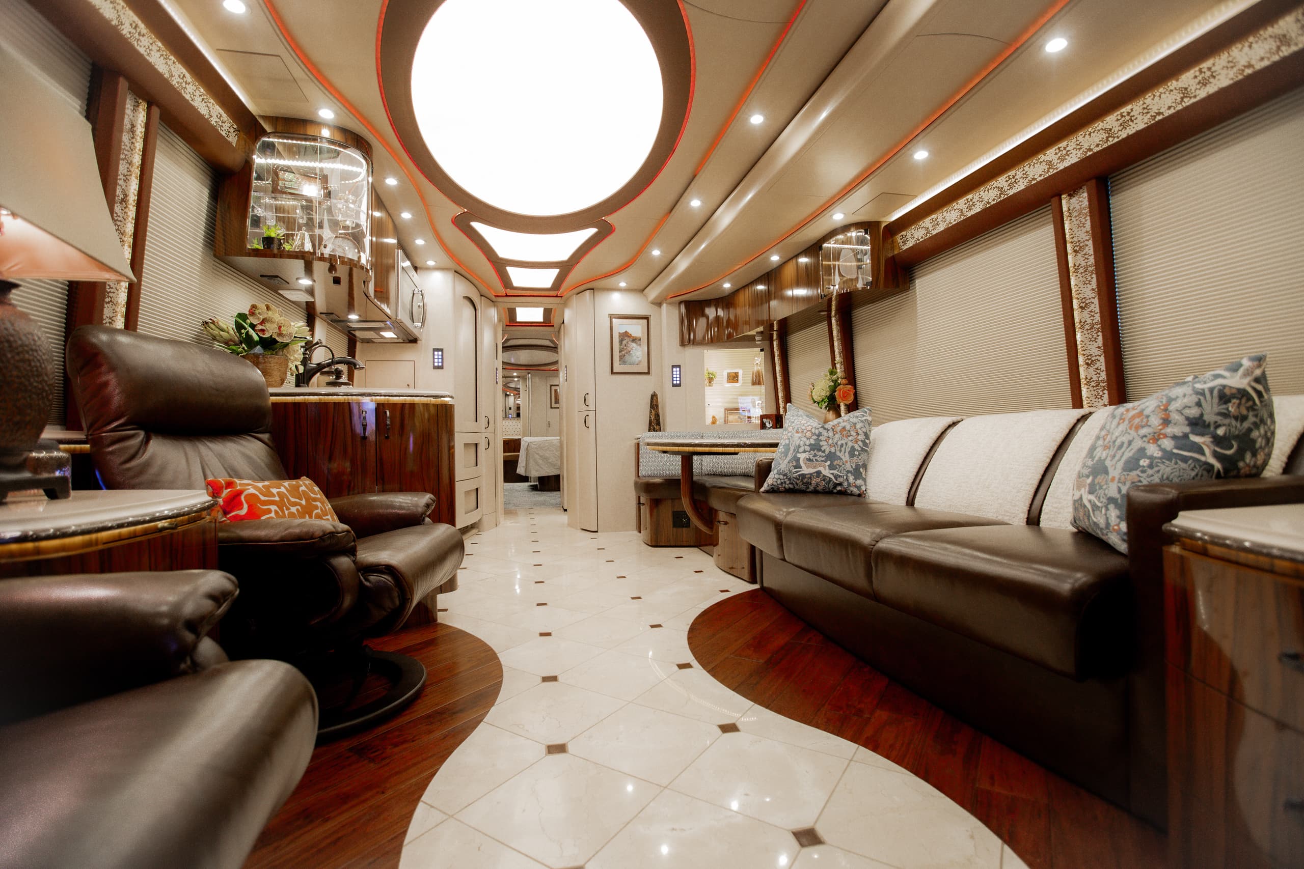 Interior of a luxury RV with red accent lighting and comfortable seating.